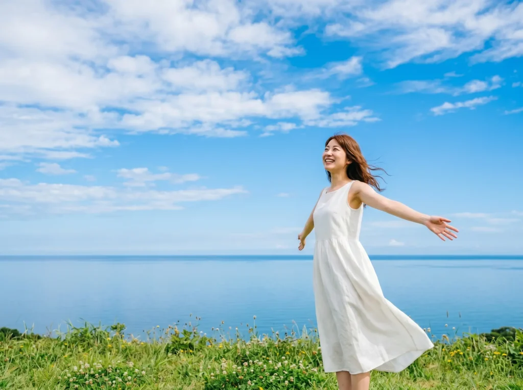青空の下で心を開く女性・本来の自分へ戻る癒しのイメージ